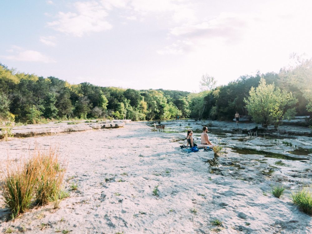 a group of people standing next to a body of water